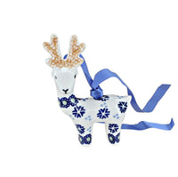 A white ceramic reindeer Christmas ornament decorated with blue floral patterns and a blue hanging ribbon, shown on a plain white background.