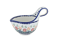 A white ceramic soup mug with a blue handle and blue rim, decorated with a colorful floral pattern in pink, orange, and green, on a white background.