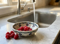 Polish pottery Blue Daisy small scalloped dish sitting next to the kitchen sink holding freshly washed raspberries