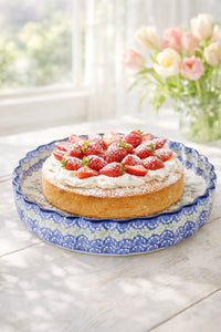 Strawberry cake on a Polish pottery Spring Tulip torte plate with a vase of flowers in the background