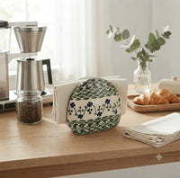 sage floral polish pottery ceramic napkin holder next to coffee maker and pastries