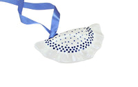 A white ceramic ornament shaped like a dumpling or dumpling with blue polka dots, featuring a blue ribbon loop at the top, shown on a plain white background.