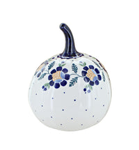 A white ceramic decorative pumpkin with a dark blue stem, decorated with blue floral motifs, green leaves, and small blue polka dots on a clean white background.
