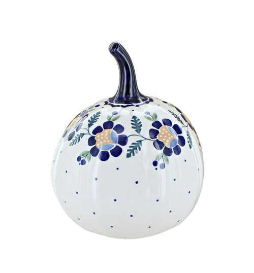 A white ceramic decorative pumpkin with a dark blue stem, decorated with blue floral motifs, green leaves, and small blue polka dots on a clean white background.