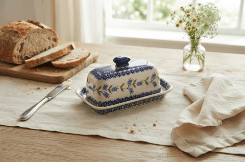 Polish pottery tulip butter dish on a linen table runner with bread and butter