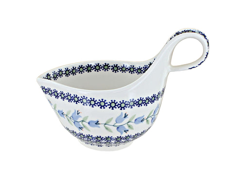 A white ceramic saucepan with a blue floral pattern and a loop handle, shown on a plain white background.