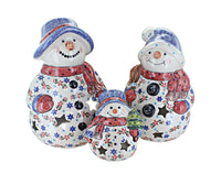 Three ceramic snowman figurines in different sizes, decorated with blue and red patterns, scarves, and hats on a plain white background.